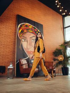 Una donna che cammina davanti a un grande dipinto di una donna di ONOMO Hotel Casablanca Sidi Maarouf a Casablanca