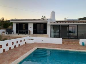 a house with a swimming pool in front of a house at Montanha Vista in Monchique