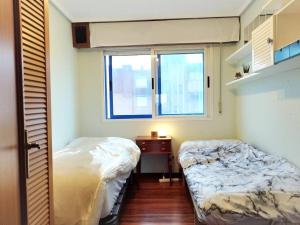 1 dormitorio con 2 camas y ventana en Castro-urdiales Apartamento compartido o entero, en Castro Urdiales