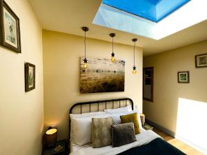 1 dormitorio con 1 cama y una pintura en la pared en Norfolk Accommodation, en Heacham