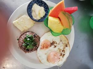 un plato de comida con huevos, pan y otros alimentos en Hotel Pasatiempo en Tamarindo