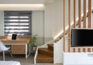 a living room with a staircase with a tv and a desk at Exclusive Villas Pappas in Sarti