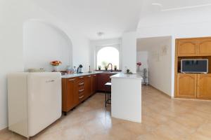 cocina con nevera blanca y armarios de madera en Birago22Capri, en Capri