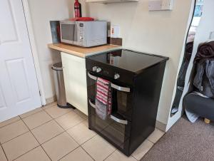 a small kitchen with a microwave on a counter at Bristol self-catering studio+kitchen+parking in Bristol