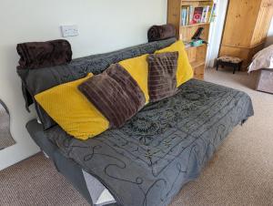 a couch with pillows on it in a living room at Bristol self-catering studio+kitchen+parking in Bristol +16 photos
