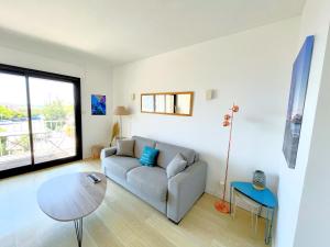 ein Wohnzimmer mit einem Sofa und einem Tisch in der Unterkunft La Rade in Cassis