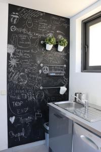 a chalkboard wall in a kitchen with plants on it at Apartamento Javali - Casas Barca do Rio by Gerês Casas in Geres