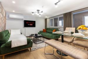 a living room with a green couch and a table at BayMari Suites City Life in Istanbul +102 photos