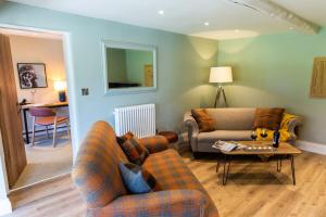 Sala de estar con 2 sofás y mesa en Sunflower Cottage en Ampleforth