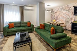 a living room with two green couches and a table at BayMari Suites City Life in Istanbul