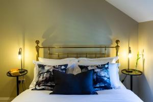 a bedroom with a bed with blue and white pillows at Sunflower Cottage in Ampleforth