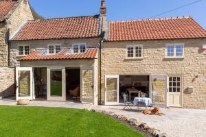 a house with a dog laying in front of it at Sunflower Cottage in Ampleforth