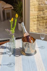 a bottle of wine in a can on a table with glasses at Sunflower Cottage in Ampleforth