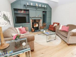 a living room with two couches and a fireplace at Gilly Skyber in Helston