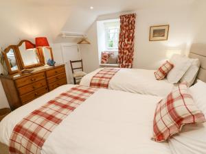 a bedroom with two beds and a mirror at Gilly Skyber in Helston