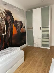 a bedroom with an elephant painting on the wall at Joanna Apartment - MA Käfertal 1 in Mannheim