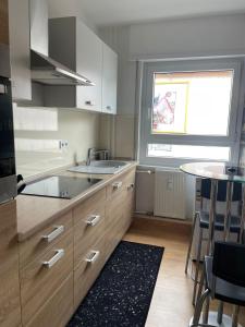 a kitchen with wooden cabinets and a table and a window at Joanna Apartment - MA Käfertal 1 in Mannheim
