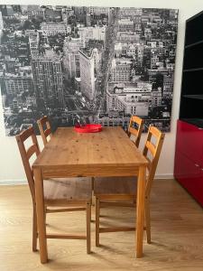 曼海姆的住宿－Joanna Apartment - MA Käfertal 1，一张带椅子的木桌和一个红色碗