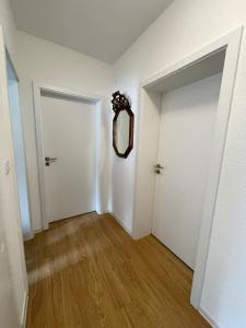 an empty hallway with a door and a mirror at Joanna Apartment - MA Käfertal 1 in Mannheim