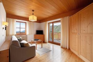 a living room with a couch and a tv at Ferienwohnungen Zwick Maroles in Malles Venosta