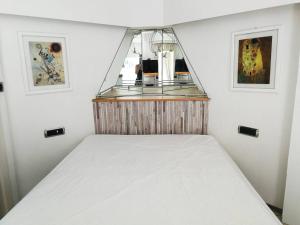 a white bed in a room with a shelf at Open space with sea view close to the Croisette in Cannes