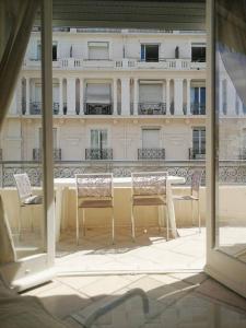 een tafel en stoelen op een balkon met een gebouw bij Open space with sea view close to the Croisette in Cannes