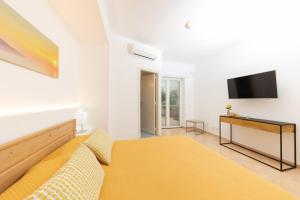 1 dormitorio con 1 cama y TV en la pared en Birago22Capri, en Capri
