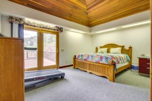 1 dormitorio con 1 cama, TV y balcón en Secluded Holter Lake Vacation Rental with Deck!, 