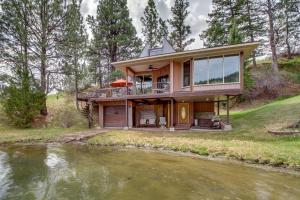 una casa en una colina junto a un río en Secluded Holter Lake Vacation Rental with Deck!, 