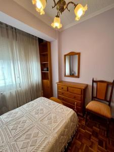 a bedroom with a bed and a dresser and a mirror at PISO EN PLENO CENTRO DE MIÑO in Miño