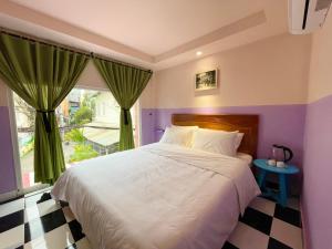 Un dormitorio con una cama grande y una ventana en Ahu Hotel & Apartment, en Ho Chi Minh