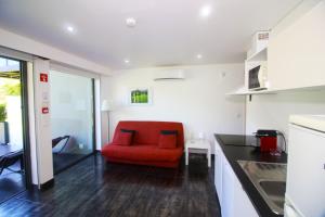 een woonkamer met een rode stoel in een keuken bij Apartamento Esquilo - Casas Barca do Rio - Geres in Geres