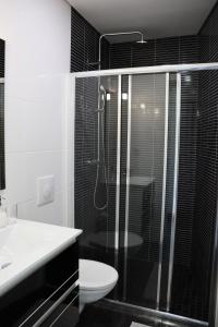 ein Bad mit einer Dusche, einem WC und einem Waschbecken in der Unterkunft Apartamento Esquilo - Casas Barca do Rio - Geres in Geres