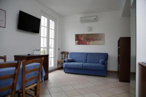 a living room with a blue couch and a tv at Residence Antico Crotto in Porlezza