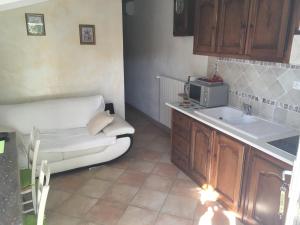 une petite cuisine avec un canapé et un évier dans l'établissement Le Nid au Pied du Mont Ventoux, à Malaucène