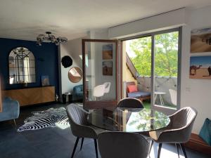 ストラスブールにあるSpacieux loft en duplexのリビングルーム(ガラスのテーブル、椅子付)