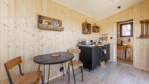 uma cozinha com uma mesa e uma pequena mesa com cadeiras em Tiny House haras Normand - 20 minutes d'Étretat 