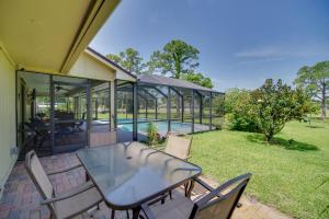 a patio with a table and chairs and a pool at Lakewood Park Retreat on Fairway - 4 Mi to Beach! in Lakewood Park
