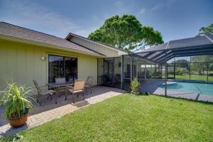 a backyard with a table and chairs and a pool at Lakewood Park Retreat on Fairway - 4 Mi to Beach! in Lakewood Park