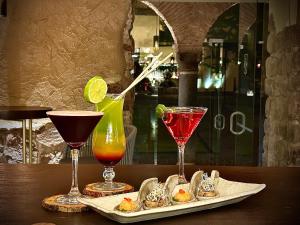 a table with three drinks and three glasses at Casa Cartagena Boutique Hotel & Spa in Cusco