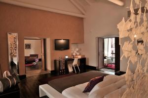 Casa Cartagena Boutique Hotel & Spa في كوسكو: غرفة معيشة بها أريكة بيضاء وتلفزيون