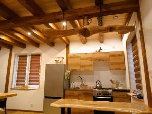 a kitchen with wooden ceilings and a stainless steel refrigerator at Zagroda Podlas - gospodarstwo agroturystyczne 2 in Aleksandrów +29 photos