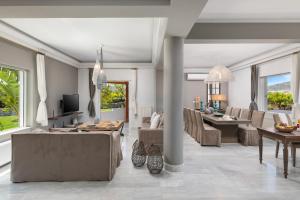 a living room with couches and a dining room at Villa Tranquilla in Kolymvari