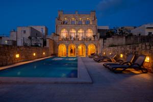 un edificio con piscina di fronte a un edificio di Home Mood B&B a Għarb