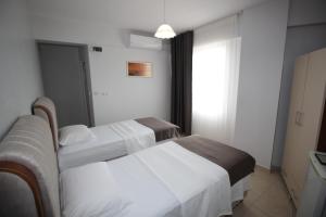 a hotel room with two beds and a window at Pegasus Motel in Avşa Adası