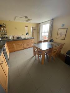 a kitchen and dining room with a table and chairs at Suffolk Riverside Cottage with Panoramic Views in Pin Mill 