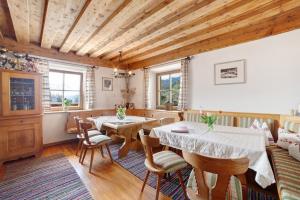 a dining room with wooden ceilings and tables and chairs at Ferienwohnungen Zwick Maroles in Malles Venosta
