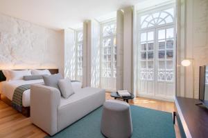 - une chambre avec un lit blanc et un canapé dans l'établissement d'ALMA Boutique Hotel, à Porto