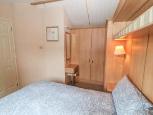 a small bedroom with a bed and a desk at Stanley's Sanctuary in Cockermouth