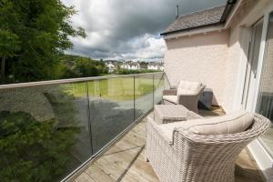 a balcony with wicker chairs and a view of a yard at Hawkshead Suites in Hawkshead